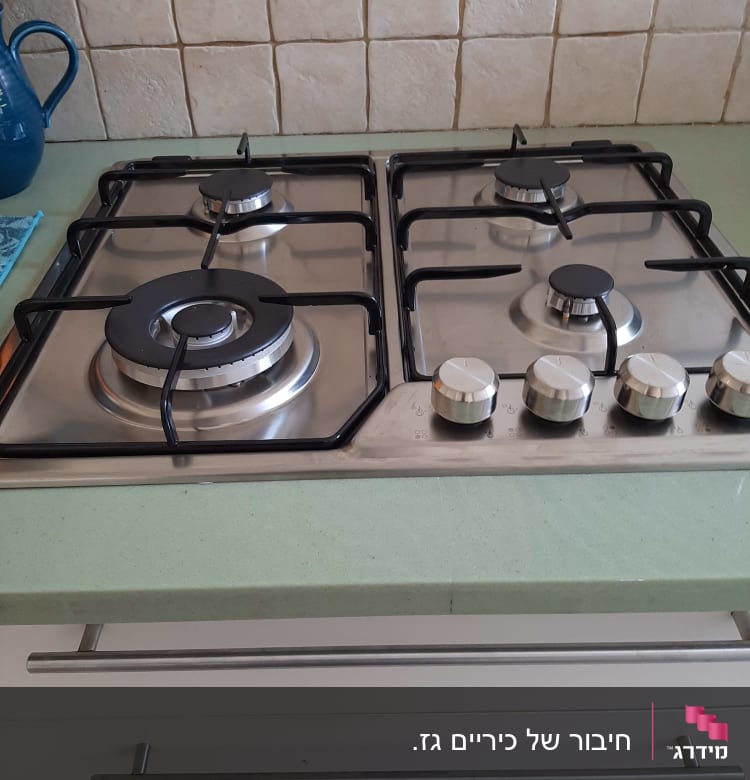 כיריים גז עם ארבעה מבערים וכפתורי שליטה